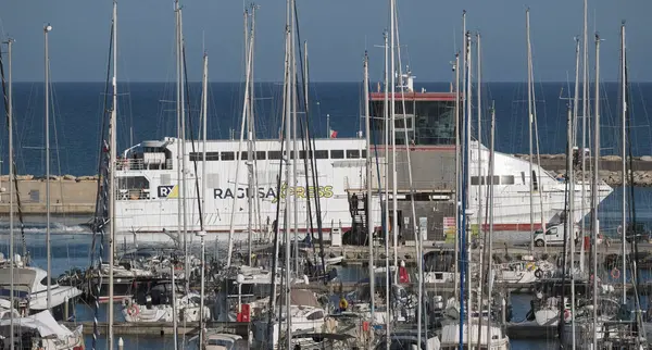 İtalya, Sicilya, Akdeniz, Marina di Ragusa (Ragusa ili); 13 Mayıs 2025, Sicilya 'yı Malta adasına bağlayan feribot ve limandaki lüks yatlar - EDITORIAL