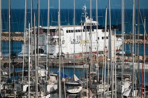 İtalya, Sicilya, Akdeniz, Marina di Ragusa (Ragusa ili); 13 Mayıs 2025, Sicilya 'yı Malta adasına bağlayan feribot ve limandaki lüks yatlar - EDITORIAL