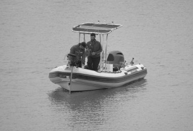 İtalya, Sicilya, Akdeniz, Marina di Ragusa (Ragusa Eyaleti); 15 Mayıs 2025, limandaki kauçuk bir teknede adamlar - EDITORIAL