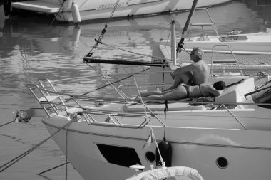 İtalya, Sicilya, Akdeniz, Marina di Ragusa (Ragusa Eyaleti); 18 Mayıs 2025, limanda lüks bir yatta çift - EDITORIAL