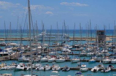 İtalya, Sicilya, Akdeniz, Marina di Ragusa (Ragusa ili); 25 Mayıs 2025, Sicilya 'yı Malta adasına bağlayan feribot ve limandaki lüks yatlar - EDITORIAL