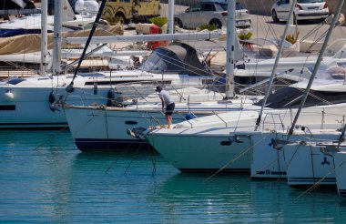 İtalya, Sicilya, Akdeniz, Marina di Ragusa (Ragusa Eyaleti); 1 Haziran 2025, limanda lüks bir yatta bir adam - EDITORIAL