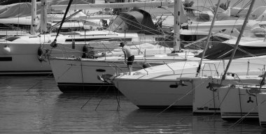 İtalya, Sicilya, Akdeniz, Marina di Ragusa (Ragusa Eyaleti); 1 Haziran 2025, limanda lüks bir yatta bir adam - EDITORIAL