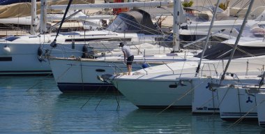 İtalya, Sicilya, Akdeniz, Marina di Ragusa (Ragusa Eyaleti); 1 Haziran 2025, limanda lüks bir yatta bir adam - EDITORIAL