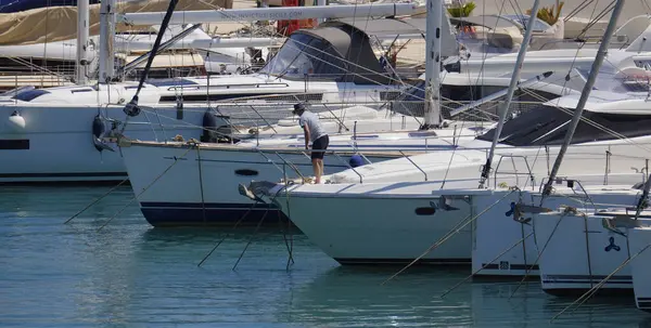 İtalya, Sicilya, Akdeniz, Marina di Ragusa (Ragusa Eyaleti); 1 Haziran 2025, limanda lüks bir yatta bir adam - EDITORIAL