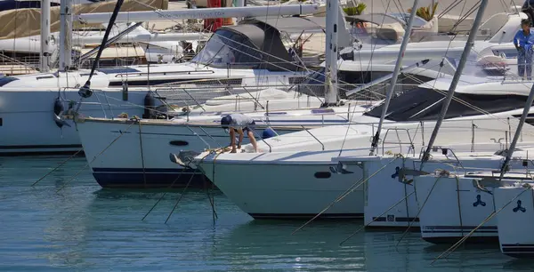 İtalya, Sicilya, Akdeniz, Marina di Ragusa (Ragusa Eyaleti); 1 Haziran 2025, limanda lüks bir yatta çift - EDITORIAL