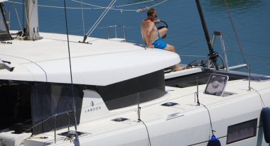 Italy, Sicily, Mediterranean sea, Marina di Ragusa (Ragusa Province); 3 June 2025, man on a catamaran sailing boat in the port - EDITORIAL