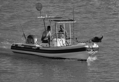 İtalya, Sicilya, Akdeniz, Marina di Ragusa (Ragusa Eyaleti); 3 Haziran 2025, limandaki lastik bir teknede balıkçılar - EDITORIAL