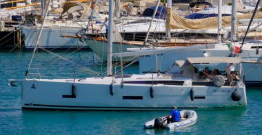 İtalya, Sicilya, Akdeniz, Marina di Ragusa (Ragusa Eyaleti); 4 Haziran 2025, limandaki bir yelkenli ve lüks yatlarda yaşayan insanlar - EDITORIAL