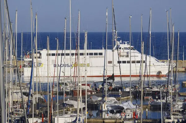 İtalya, Sicilya, Akdeniz, Marina di Ragusa (Ragusa ili); 4 Haziran 2025, Sicilya 'yı Malta adasına bağlayan feribot ve limandaki lüks yatlar - EDITORIAL