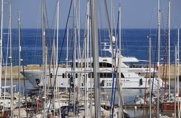 İtalya, Sicilya, Akdeniz, Marina di Ragusa (Ragusa Eyaleti); limana giren büyük lüks bir yatın manzarası 