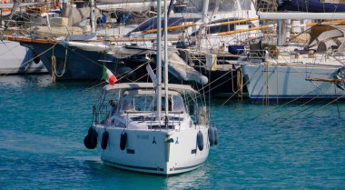 İtalya, Sicilya, Akdeniz, Marina di Ragusa (Ragusa Eyaleti); 4 Haziran 2025, limandaki bir yelkenli ve lüks yatlarda yaşayan insanlar - EDITORIAL