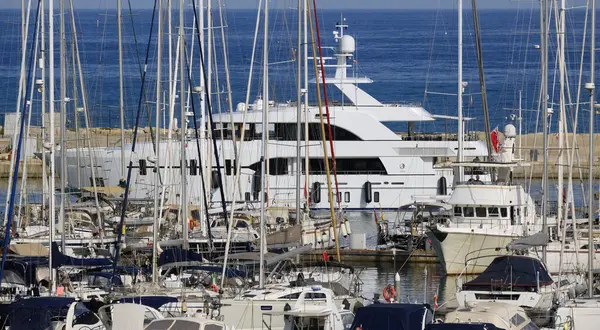 İtalya, Sicilya, Akdeniz, Marina di Ragusa (Ragusa Eyaleti); limana giren büyük lüks bir yatın manzarası 