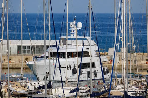 İtalya, Sicilya, Akdeniz, Marina di Ragusa (Ragusa Eyaleti); limana giren büyük lüks bir yatın manzarası 