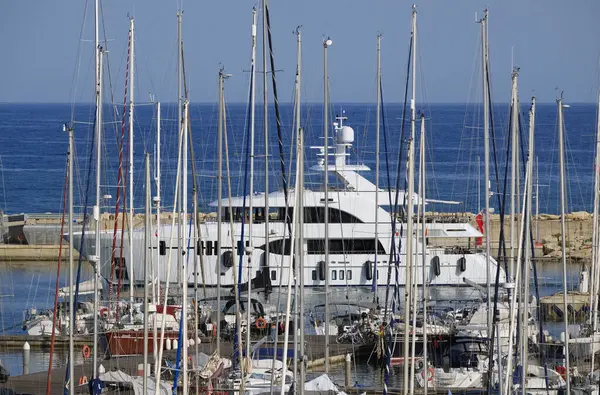 İtalya, Sicilya, Akdeniz, Marina di Ragusa (Ragusa Eyaleti); limana giren büyük lüks bir yatın manzarası 