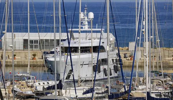 İtalya, Sicilya, Akdeniz, Marina di Ragusa (Ragusa Eyaleti); limana giren büyük lüks bir yatın manzarası 