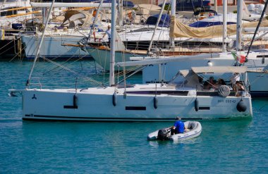 İtalya, Sicilya, Akdeniz, Marina di Ragusa (Ragusa Eyaleti); 4 Haziran 2025, limandaki bir yelkenli ve lüks yatlarda yaşayan insanlar - EDITORIAL