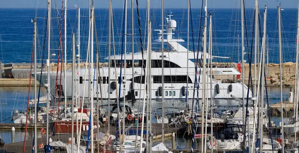 İtalya, Sicilya, Akdeniz, Marina di Ragusa (Ragusa Eyaleti); limana giren büyük lüks bir yatın manzarası 
