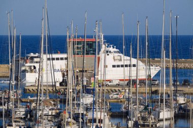 İtalya, Sicilya, Akdeniz, Marina di Ragusa (Ragusa ili); 4 Haziran 2025, Sicilya 'yı Malta adasına bağlayan feribot ve limandaki lüks yatlar - EDITORIAL