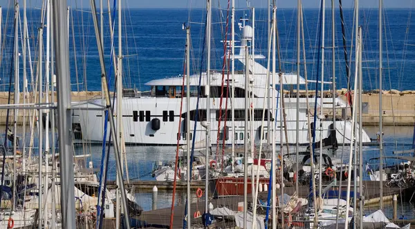 İtalya, Sicilya, Akdeniz, Marina di Ragusa (Ragusa Eyaleti); limana giren büyük lüks bir yatın manzarası 