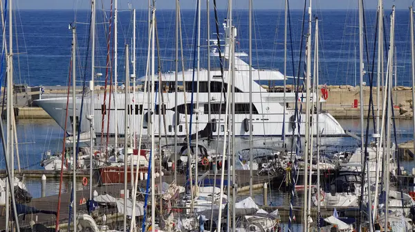 İtalya, Sicilya, Akdeniz, Marina di Ragusa (Ragusa Eyaleti); limana giren büyük lüks bir yatın manzarası 