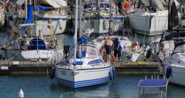 İtalya, Sicilya, Akdeniz, Marina di Ragusa (Ragusa ili); 7 Haziran 2025, limandaki bir yelkenli teknesinde erkekler - EDITORIAL