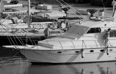 İtalya, Sicilya, Akdeniz, Marina di Ragusa (Ragusa Eyaleti); 7 Haziran 2025, limanda lüks bir yatı temizleyen çift - EDITORIAL