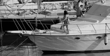 İtalya, Sicilya, Akdeniz, Marina di Ragusa (Ragusa Eyaleti); limanda lüks bir yatı temizleyen çift 