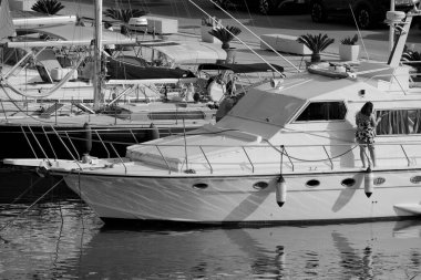 İtalya, Sicilya, Akdeniz, Marina di Ragusa (Ragusa Eyaleti); limanda lüks bir yatı temizleyen çift 