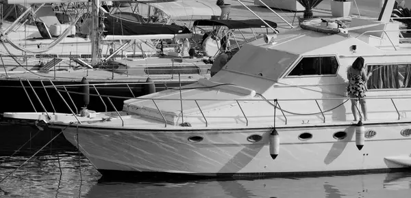 İtalya, Sicilya, Akdeniz, Marina di Ragusa (Ragusa Eyaleti); limanda lüks bir yatı temizleyen çift 