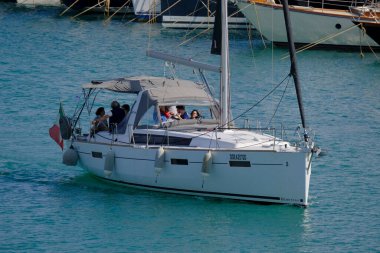 İtalya, Sicilya, Akdeniz, Marina di Ragusa (Ragusa ili); 8 Haziran 2025, limandaki bir yelkenli teknesinde insanlar - EDITORIAL