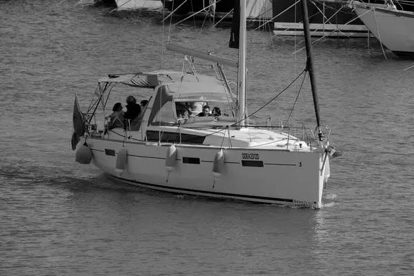 İtalya, Sicilya, Akdeniz, Marina di Ragusa (Ragusa ili); 8 Haziran 2025, limandaki bir yelkenli teknesinde insanlar - EDITORIAL