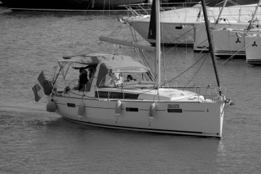 İtalya, Sicilya, Akdeniz, Marina di Ragusa (Ragusa ili); 8 Haziran 2025, limandaki bir yelkenli teknesinde insanlar - EDITORIAL