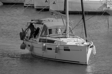 İtalya, Sicilya, Akdeniz, Marina di Ragusa (Ragusa ili); 8 Haziran 2025, limandaki bir yelkenli teknesinde insanlar - EDITORIAL