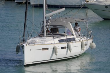 İtalya, Sicilya, Akdeniz, Marina di Ragusa (Ragusa ili); 8 Haziran 2025, limandaki bir yelkenli teknesinde insanlar - EDITORIAL