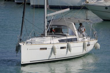 İtalya, Sicilya, Akdeniz, Marina di Ragusa (Ragusa ili); 8 Haziran 2025, limandaki bir yelkenli teknesinde insanlar - EDITORIAL