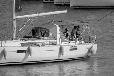 İtalya, Sicilya, Akdeniz, Marina di Ragusa (Ragusa ili); 8 Haziran 2025, limandaki bir yelkenli teknesinde insanlar - EDITORIAL