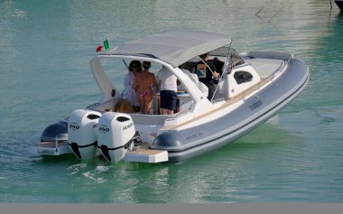 İtalya, Sicilya, Akdeniz, Marina di Ragusa (Ragusa Eyaleti); 8 Haziran 2025, limandaki büyük bir kauçuk teknede insanlar - EDITORIAL