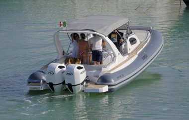 İtalya, Sicilya, Akdeniz, Marina di Ragusa (Ragusa Eyaleti); 8 Haziran 2025, limandaki büyük bir kauçuk teknede insanlar - EDITORIAL