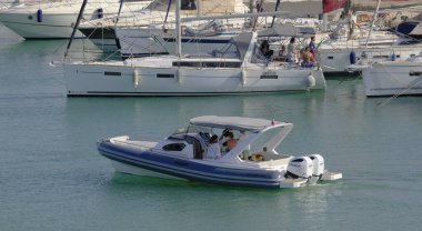 İtalya, Sicilya, Akdeniz, Marina di Ragusa (Ragusa Eyaleti); 8 Haziran 2025, limandaki motorlu tekne ve lüks yatlarda yaşayan insanlar - EDITORIAL