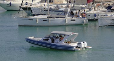 İtalya, Sicilya, Akdeniz, Marina di Ragusa (Ragusa Eyaleti); 8 Haziran 2025, limandaki motorlu tekne ve lüks yatlarda yaşayan insanlar - EDITORIAL