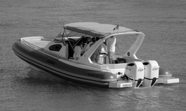 İtalya, Sicilya, Akdeniz, Marina di Ragusa (Ragusa Eyaleti); 8 Haziran 2025, limandaki büyük bir kauçuk teknede insanlar - EDITORIAL