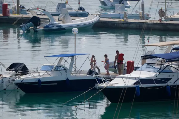 İtalya, Sicilya, Akdeniz, Marina di Ragusa (Ragusa ili); 14 Haziran 2025, limanda insanlar, motorlu tekneler ve lüks yatlar - EDITORIAL