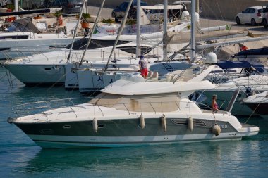 İtalya, Sicilya, Akdeniz, Marina di Ragusa (Ragusa Eyaleti); 15 Haziran 2025, limanda lüks bir yatta çift - EDITORIAL