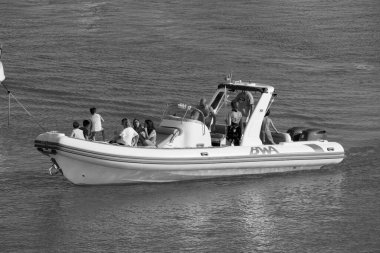 İtalya, Sicilya, Akdeniz, Marina di Ragusa (Ragusa ili); 15 Haziran 2025, limandaki büyük bir kauçuk teknede insanlar - EDITORIAL