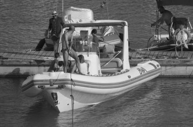 İtalya, Sicilya, Akdeniz, Marina di Ragusa (Ragusa ili); 15 Haziran 2025, limandaki büyük bir kauçuk teknede insanlar - EDITORIAL