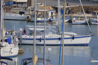 İtalya, Sicilya, Akdeniz, Marina di Ragusa (Ragusa ili); 21 Haziran 2025, limandaki bir yelkenli teknesinde çift - EDITORIAL