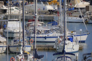 İtalya, Sicilya, Akdeniz, Marina di Ragusa (Ragusa ili); 21 Haziran 2025, limandaki bir yelkenli teknesinde çift - EDITORIAL