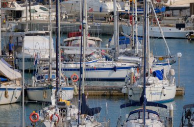 İtalya, Sicilya, Akdeniz, Marina di Ragusa (Ragusa ili); 21 Haziran 2025, limandaki bir yelkenli teknesinde çift - EDITORIAL