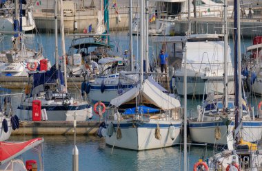 İtalya, Sicilya, Akdeniz, Marina di Ragusa (Ragusa ili); 21 Haziran 2025, limandaki bir yelkenli teknesinde çift - EDITORIAL